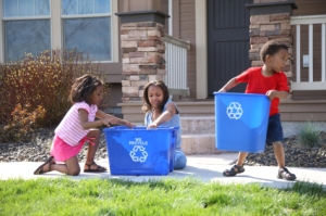 Children placing items in a Blue Box for recycling